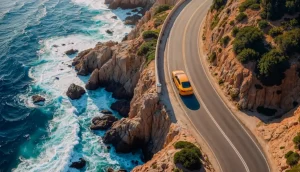Coastal road with a yellow car, ocean and cliff scenery
