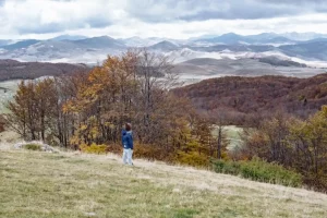 Little boy in funny hat looking at the Durmitor mountains Montenegro