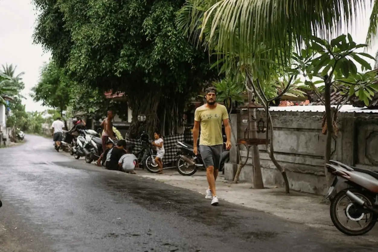 Balinese village, children hide from the rain in a gazeba under a canopy.